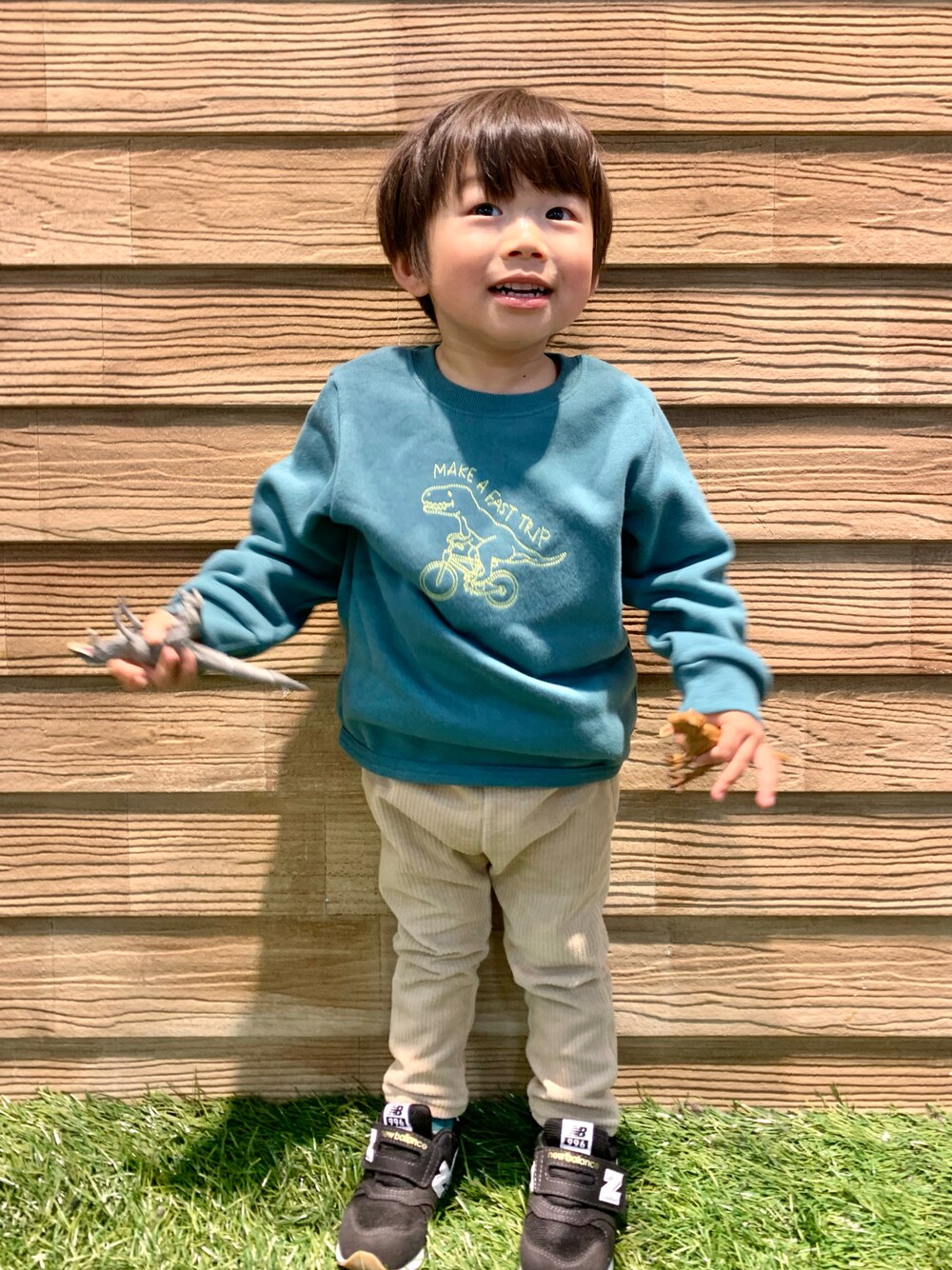 グリーン系のスウェット、ベージュ系のパンツ、ホワイト系のその他を着用したキッズの冬コーディネートの1枚目の写真