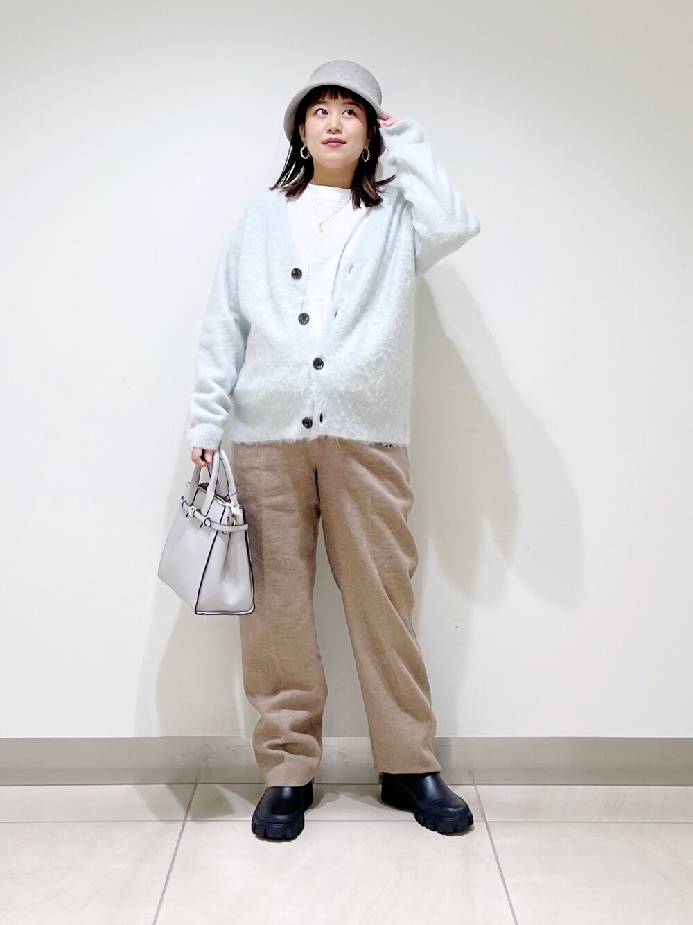 グリーン系のカーディガン/ボレロ、ベージュ系のその他パンツ、ブラック系のブーツを着用したレディースの秋コーディネートの1枚目の写真