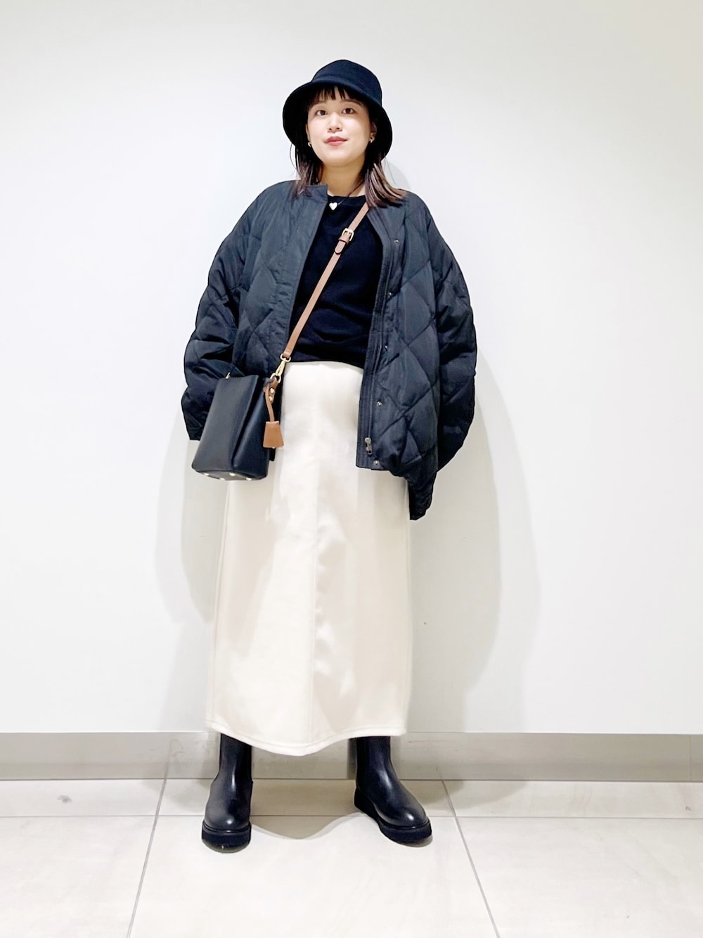 ブラック系のTシャツ/カットソー、ブラック系のその他アウター、ホワイト系のスカートを着用したレディースの秋コーディネートの1枚目の写真