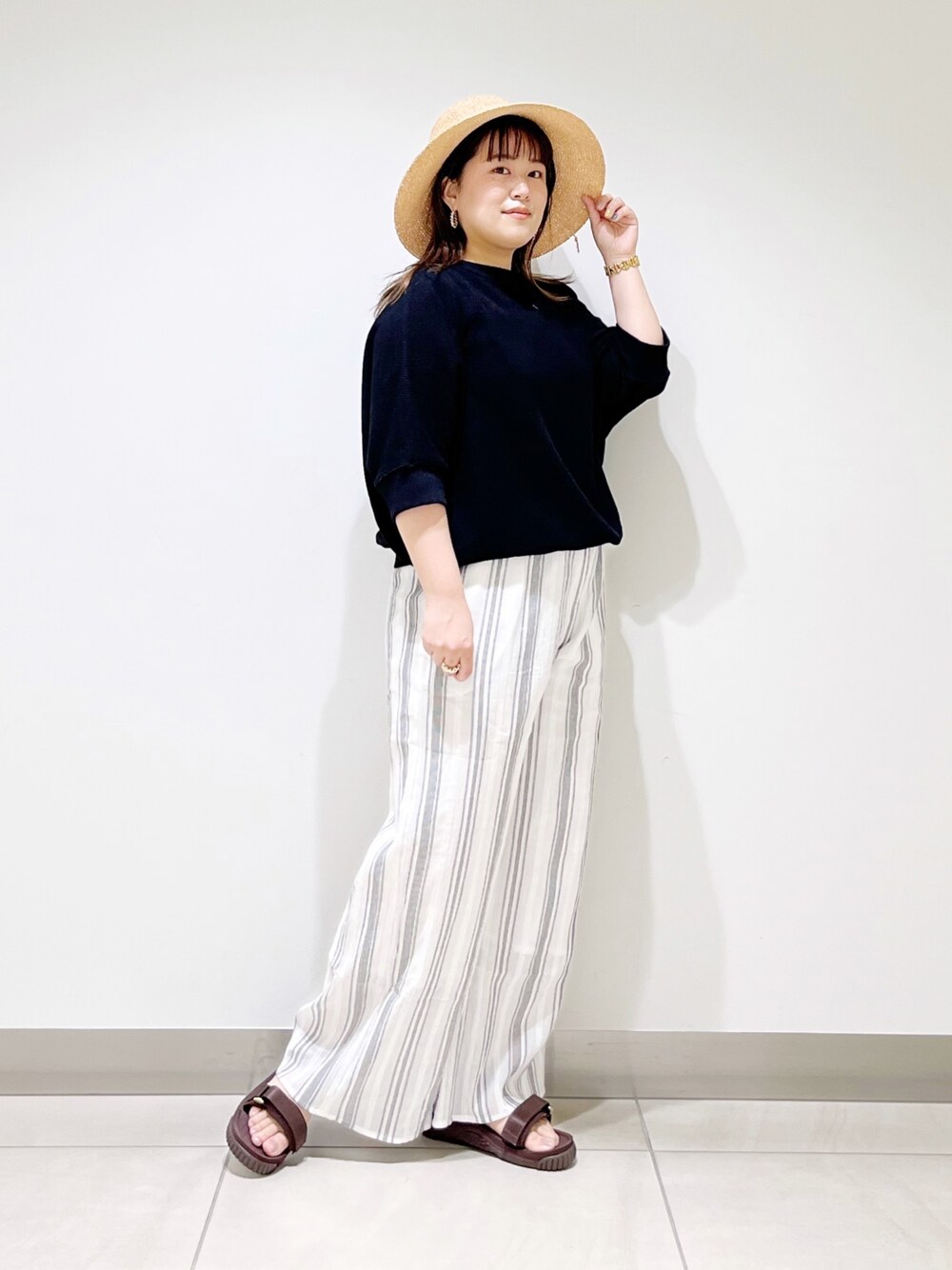 ブラック系のTシャツ/カットソー、ホワイト系のその他パンツ、ブラウン系のサンダルを着用したレディースの春コーディネートの1枚目の写真