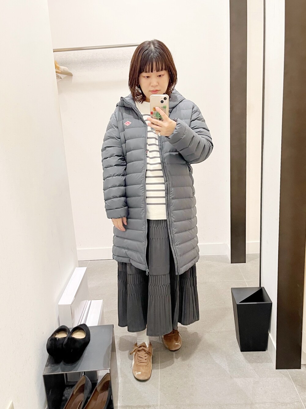 グレー系のその他アウター、グレー系のニット/セーター、グレー系のスカートを着用したレディースの秋コーディネートの1枚目の写真