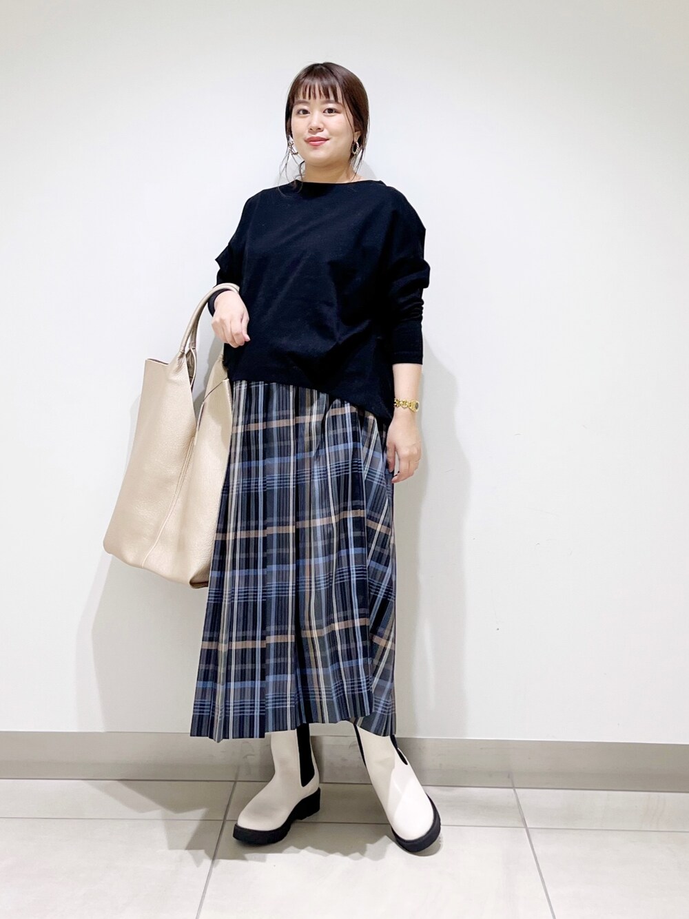 ブラック系のTシャツ/カットソー、ゴールド系のトートバッグ、ホワイト系のブーツを着用したレディースの秋コーディネートの1枚目の写真
