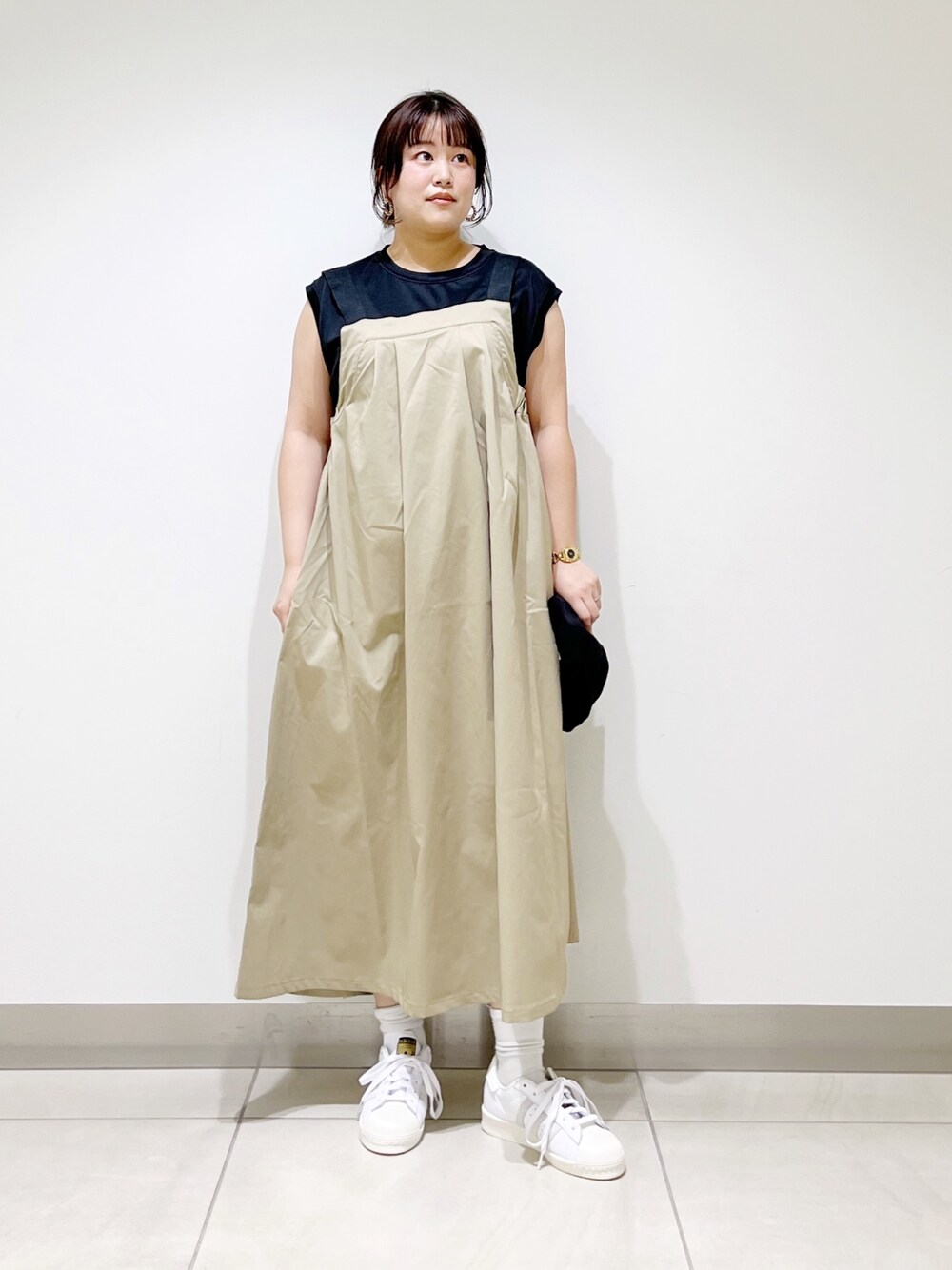 ブラック系のTシャツ/カットソー、ベージュ系のワンピース、ホワイト系のスニーカーを着用したレディースの春コーディネートの1枚目の写真