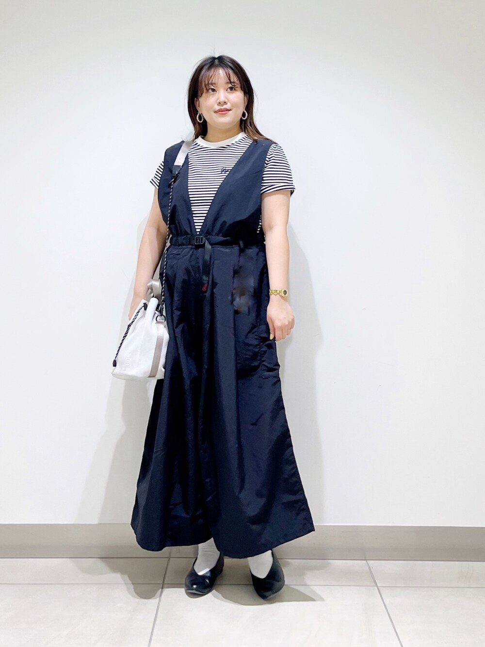ブラック系のサロペット/オーバーオール、グレー系のTシャツ/カットソー、ホワイト系のショルダーバッグを着用したレディースの春コーディネートの1枚目の写真