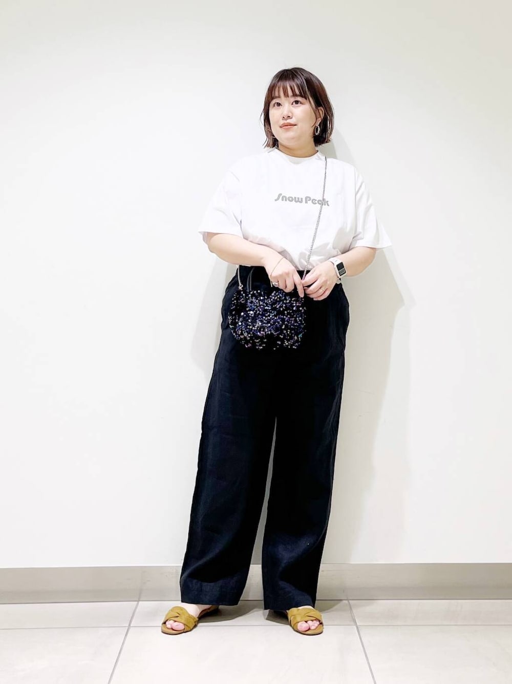 ブラック系のショルダーバッグ、ブラック系のその他パンツ、イエロー系のサンダルを着用したレディースの春コーディネートの1枚目の写真