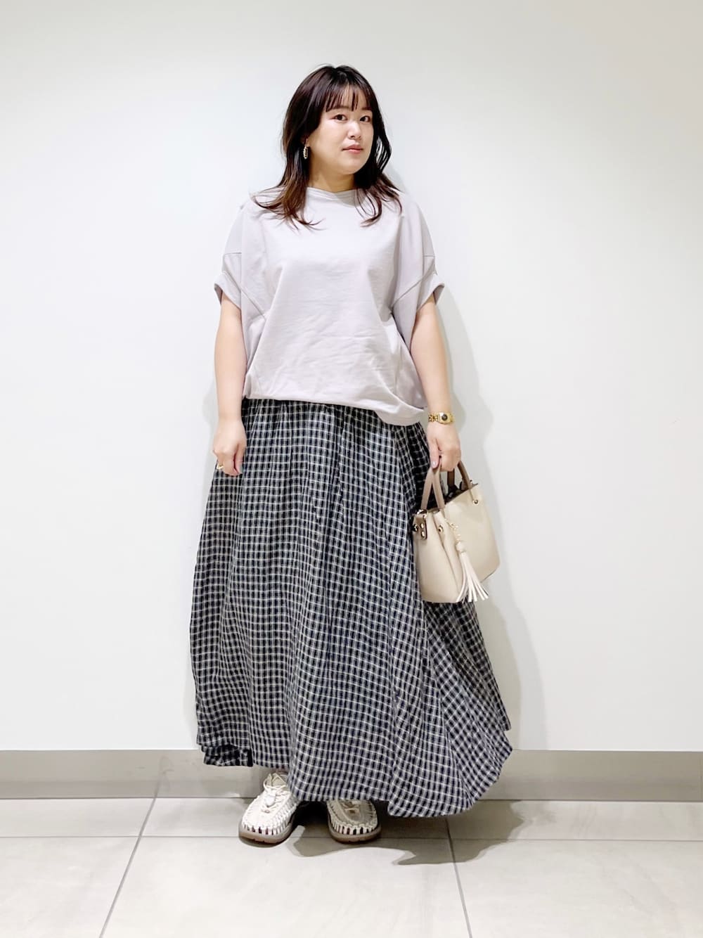 グレー系のTシャツ/カットソー、その他のスカート、ホワイト系のトートバッグを着用したレディースの春コーディネートの1枚目の写真