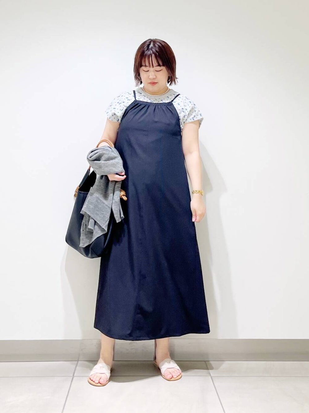 ブラック系のトートバッグ、グレー系のカーディガン/ボレロ、ホワイト系のサンダルを着用したレディースの春コーディネートの1枚目の写真