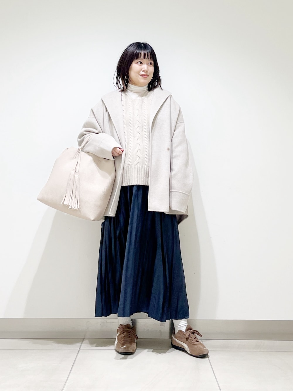 ベージュ系のその他アウター、ベージュ系のニット/セーター、ホワイト系のトートバッグを着用したレディースの秋コーディネートの1枚目の写真