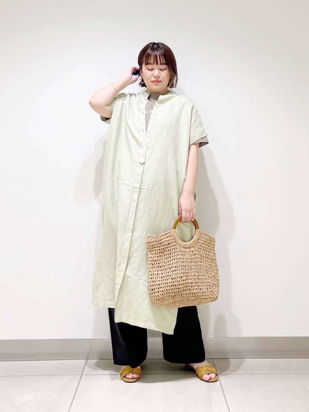 ブラック系のその他パンツ、グリーン系のワンピース、ベージュ系のトートバッグを着用したレディースの春コーディネートの1枚目の写真