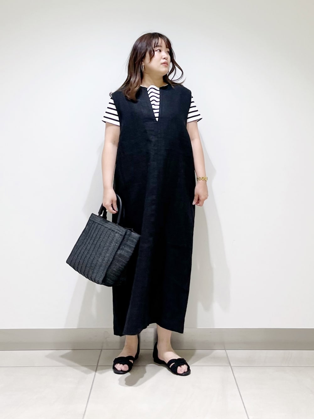 ブラック系のワンピース、ブラック系のTシャツ/カットソー、ブラック系のバッグを着用したレディースの春コーディネートの1枚目の写真
