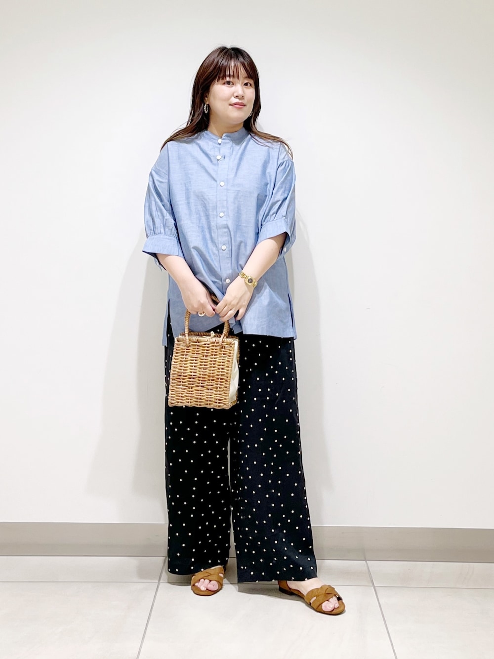 ブルー系のシャツ/ブラウス、ブラック系のその他パンツ、ベージュ系のハンドバッグを着用したレディースの夏コーディネートの1枚目の写真
