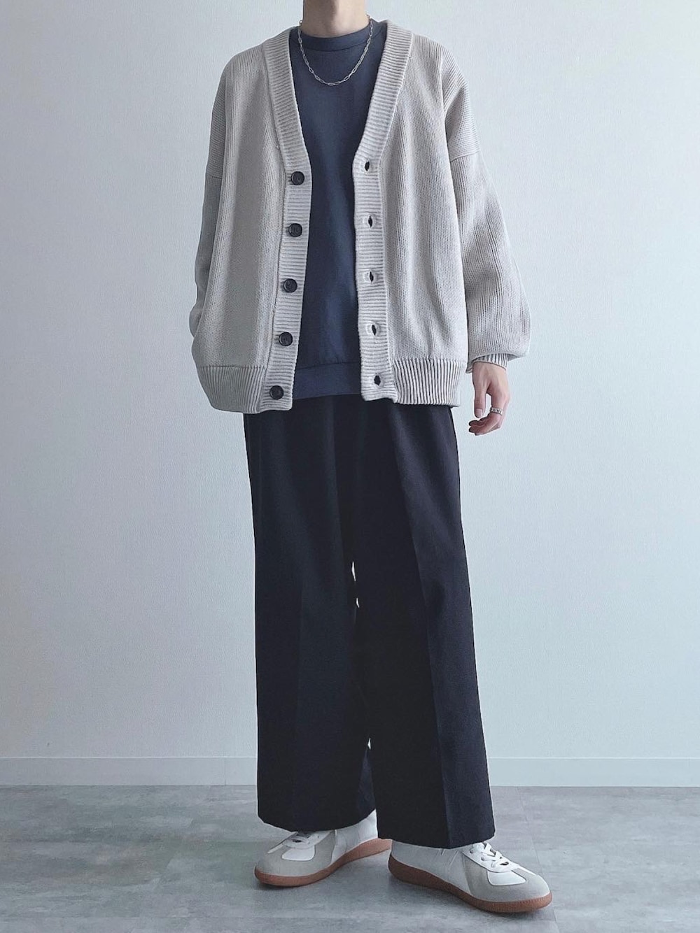グレー系のカーディガン/ボレロ、ブルー系のトップス、ブラック系のスラックスを着用したメンズの秋コーディネートの1枚目の写真