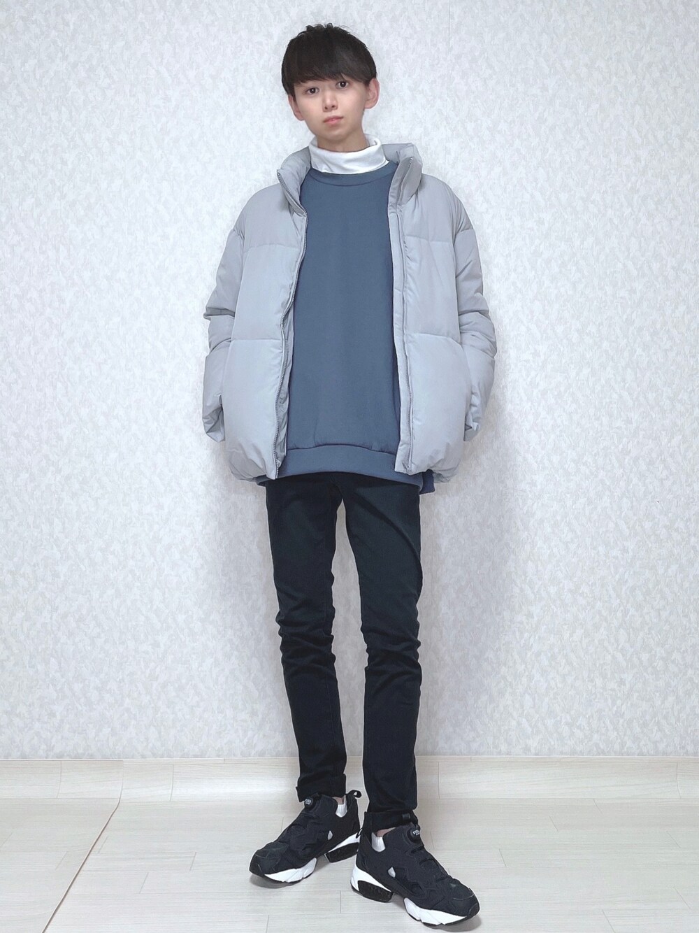 グレー系のダウンジャケット/コート、ブルー系のトップス、ホワイト系のTシャツ/カットソーを着用したメンズの冬コーディネートの1枚目の写真