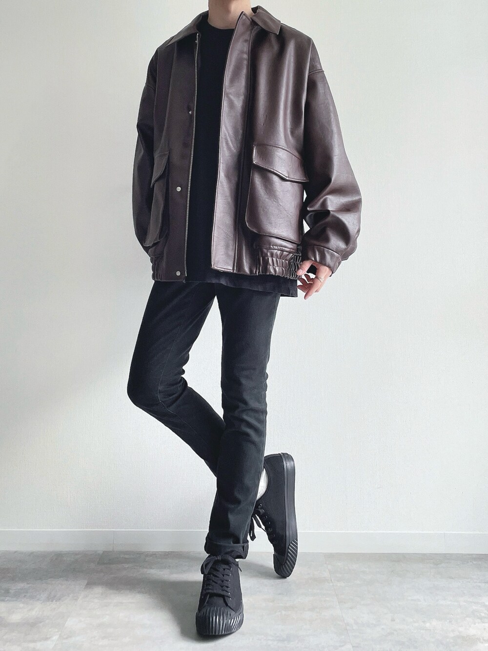 ブラウン系のブルゾン、ブラック系のTシャツ/カットソー、ブラック系のパンツを着用したメンズの冬コーディネートの1枚目の写真