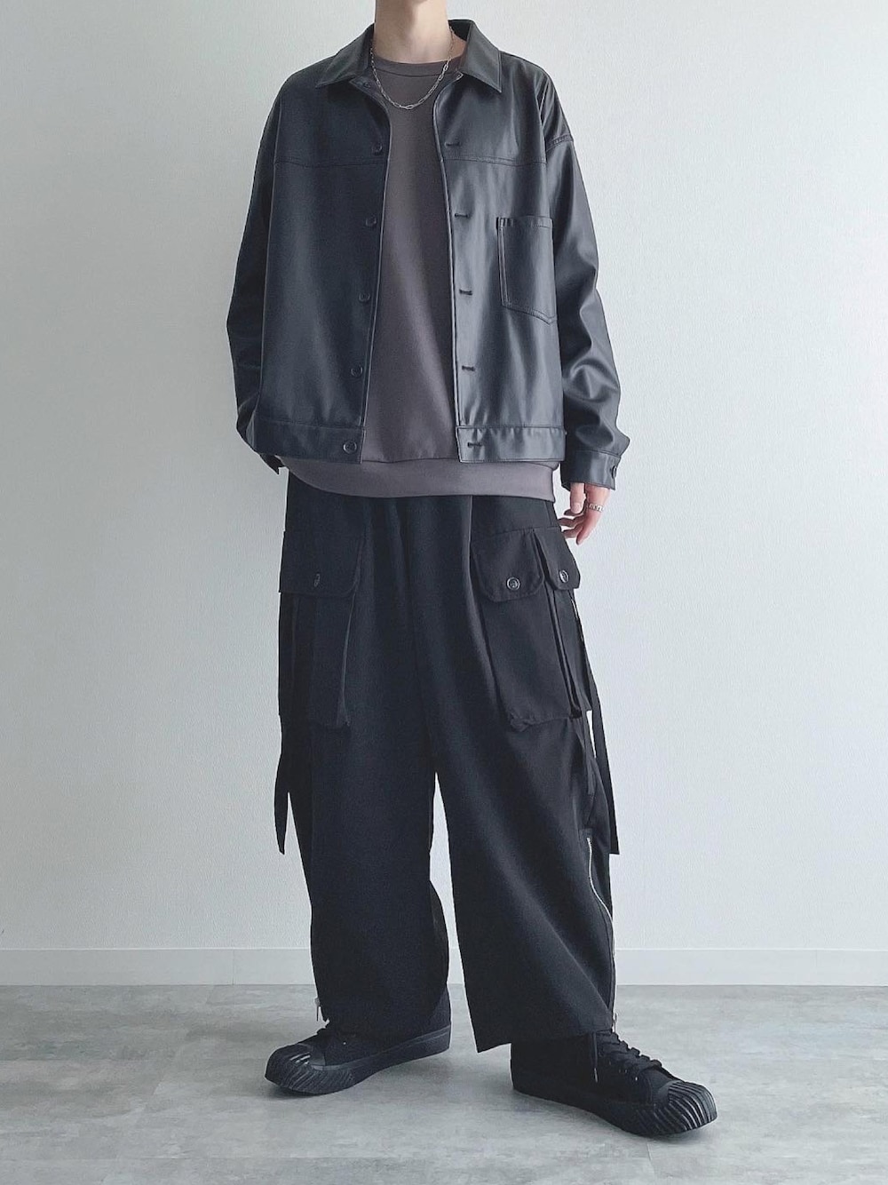 ブラック系のブルゾン、グレー系のトップス、ブラック系のカーゴパンツを着用したメンズの秋コーディネートの1枚目の写真