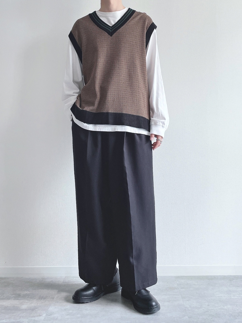 ホワイト系のTシャツ/カットソー、ブラウン系のトップス、ブラック系のスラックスを着用したメンズの秋コーディネートの1枚目の写真