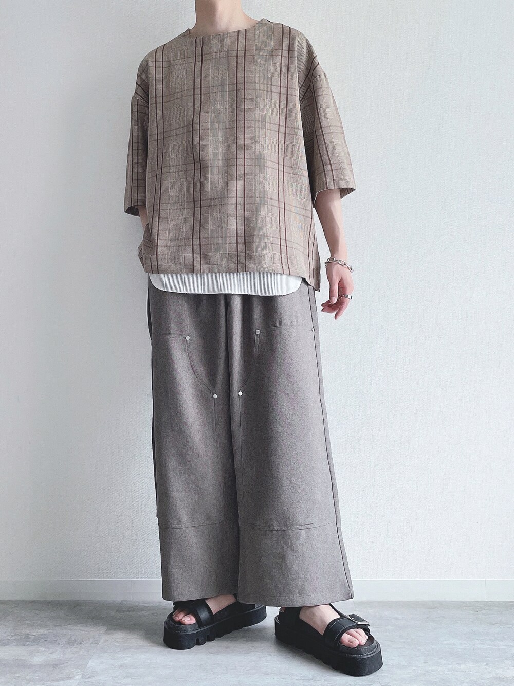 ブラウン系のTシャツ/カットソー、ホワイト系のタンクトップ、ベージュ系のスラックスを着用したメンズの夏コーディネートの1枚目の写真