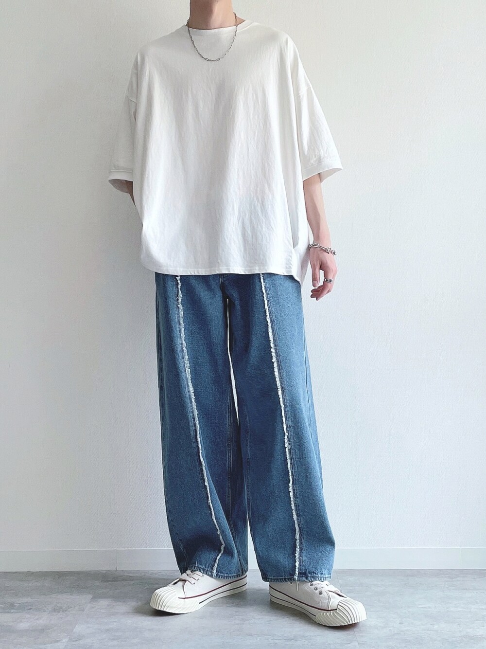 ホワイト系のTシャツ/カットソー、ブルー系のデニムパンツ、ホワイト系のスニーカーを着用したメンズの春コーディネートの1枚目の写真