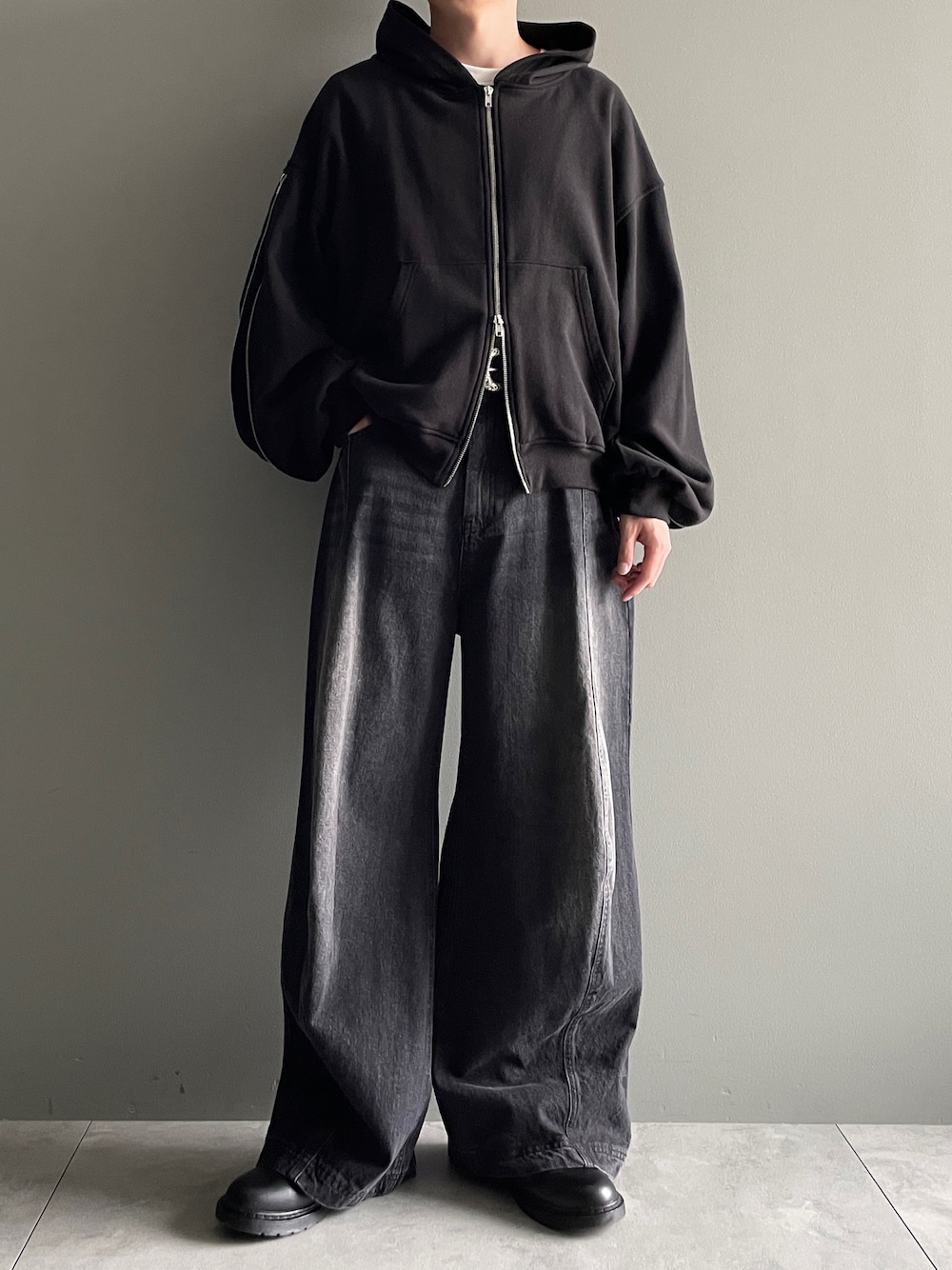 ブラック系のパーカー、ブラック系のデニムパンツ、ホワイト系のTシャツ/カットソーを着用したメンズの冬コーディネートの1枚目の写真