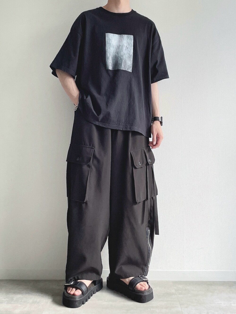 ブラック系のTシャツ/カットソー、ブラック系のカーゴパンツ、ブラック系のサンダルを着用したメンズの夏コーディネートの1枚目の写真
