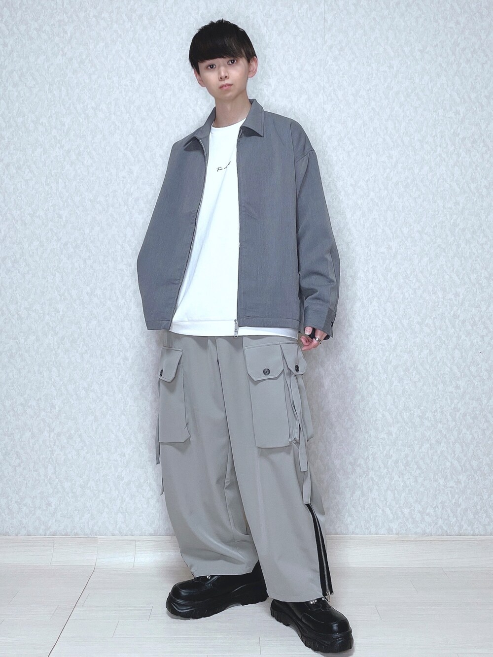 グレー系のブルゾン、ホワイト系のTシャツ/カットソー、グレー系のカーゴパンツを着用したメンズの春コーディネートの1枚目の写真