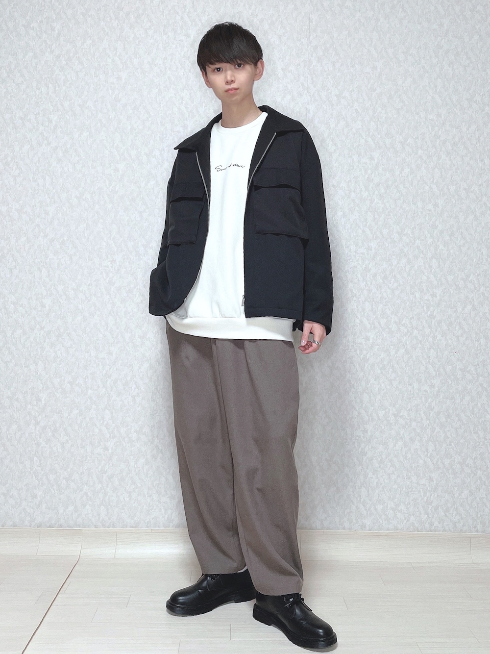 ブラック系のセットアップ、ホワイト系のスウェット、グリーン系のパンツを着用したメンズの冬コーディネートの1枚目の写真