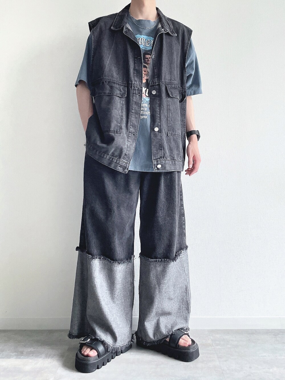 ブラック系のベスト、ブルー系のTシャツ/カットソー、ブラック系のデニムパンツを着用したメンズの夏コーディネートの1枚目の写真