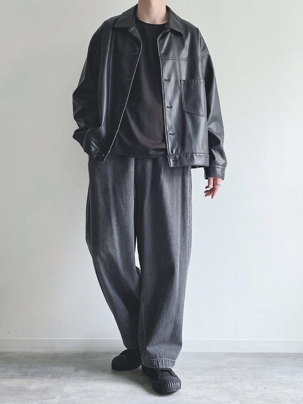 ブラック系のブルゾン、ブラック系のTシャツ/カットソー、ブラック系のデニムパンツを着用したメンズの秋コーディネートの1枚目の写真