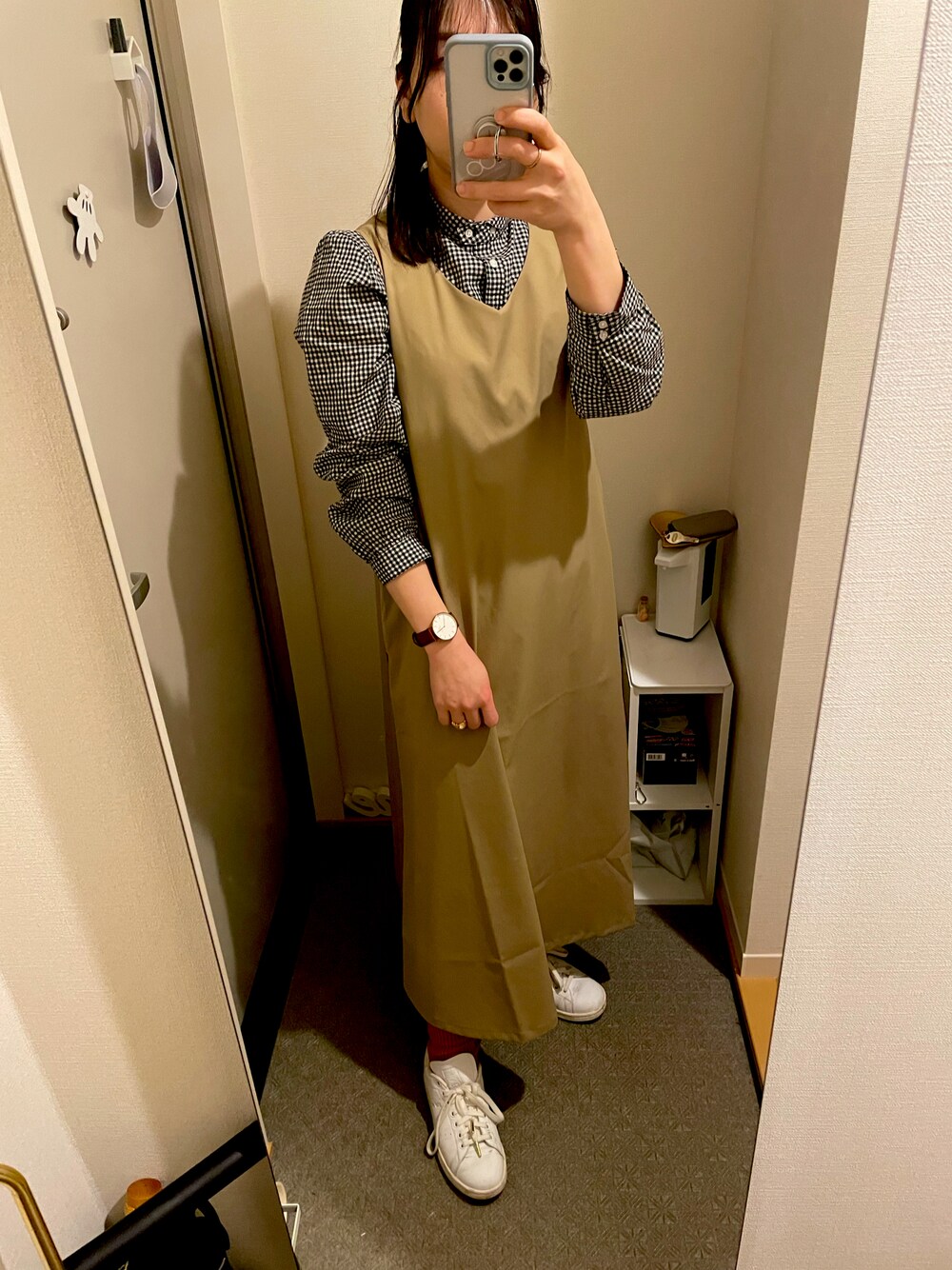 ホワイト系のスニーカー、ベージュ系のワンピース、ブラック系のシャツ/ブラウスを着用したレディースの春コーディネートの1枚目の写真