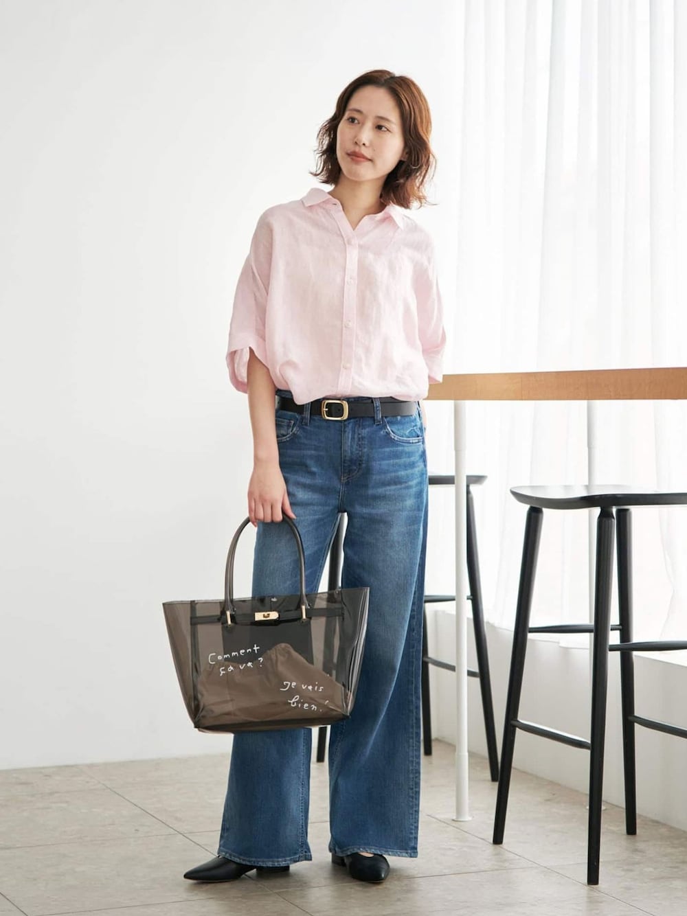 ブルー系のデニムパンツ、ピンク系のシャツ/ブラウス、ブラック系のトートバッグを着用したレディースの夏コーディネートの1枚目の写真