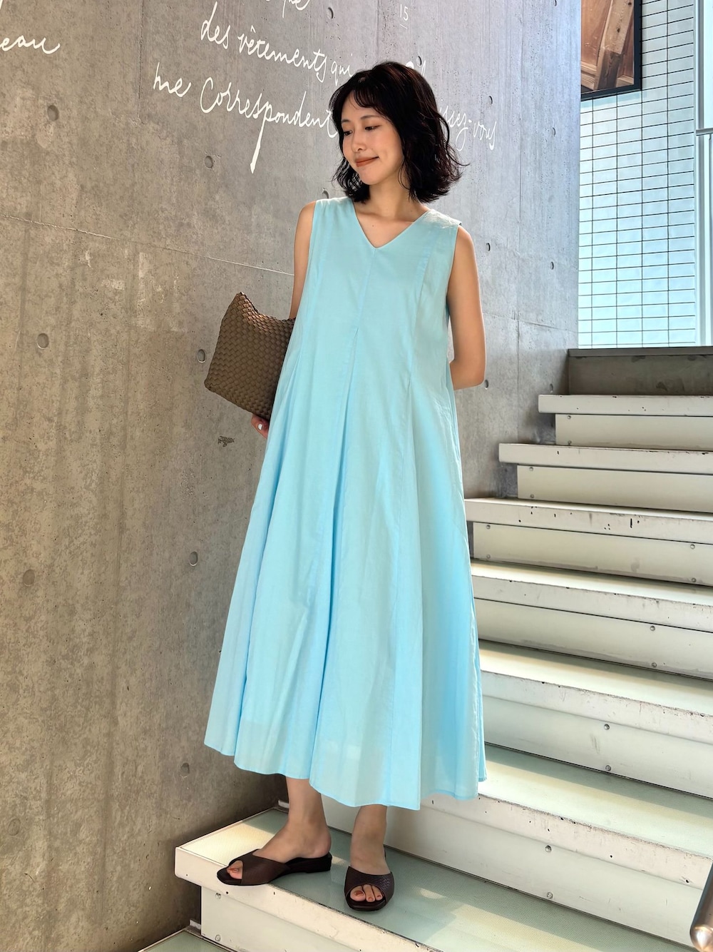 ブルー系のワンピース、ブラウン系のトートバッグ、ブラウン系のサンダルを着用したレディースの夏コーディネートの1枚目の写真