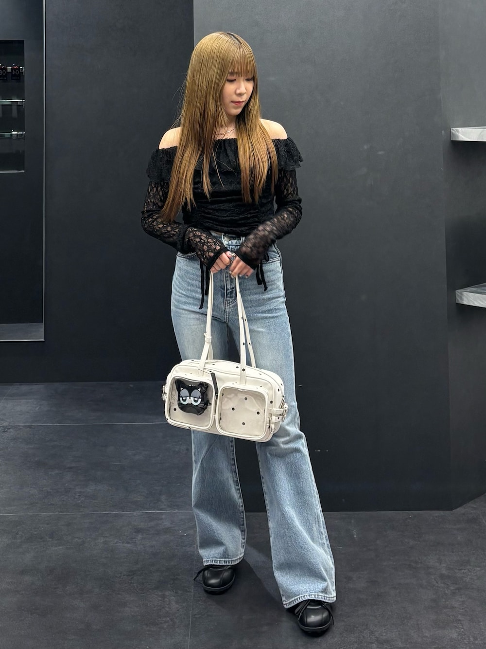 ブラック系のTシャツ/カットソー、ブルー系のデニムパンツ、ホワイト系のショルダーバッグを着用したレディースの春コーディネートの1枚目の写真