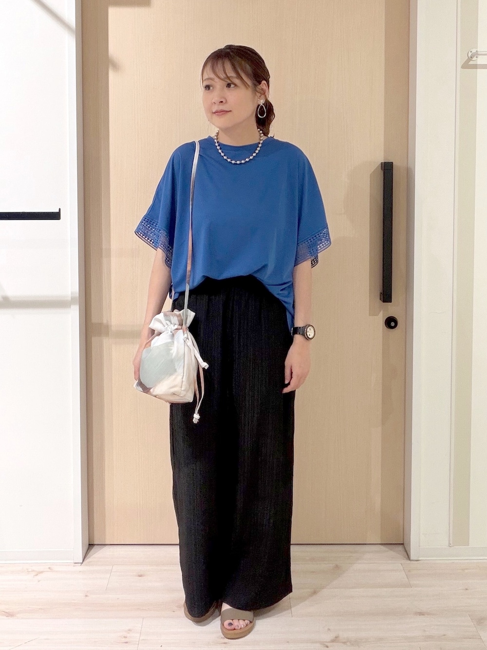 ブルー系のTシャツ/カットソー、ブラック系のその他パンツ、ブラウン系のサンダルを着用したレディースの夏コーディネートの1枚目の写真