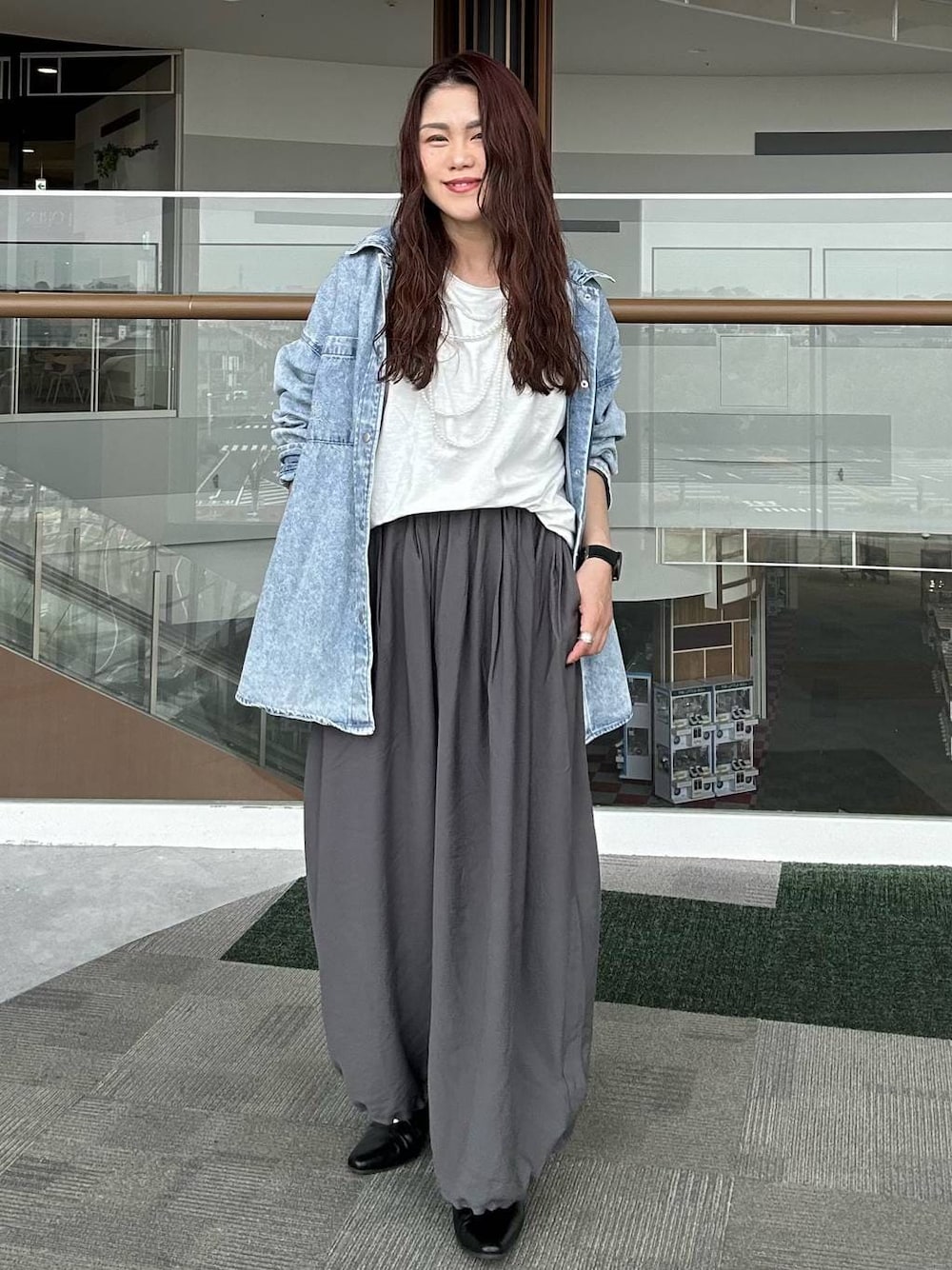 ブルー系のシャツ/ブラウス、ブラック系のパンプス、ホワイト系のTシャツ/カットソーを着用したレディースの春コーディネートの1枚目の写真