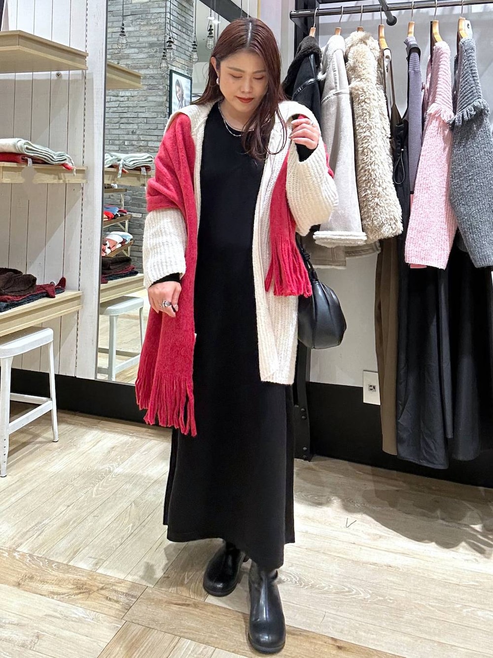 ブラック系のブーツ、ブラック系のショルダーバッグ、ブラック系のワンピースを着用したレディースの秋コーディネートの1枚目の写真