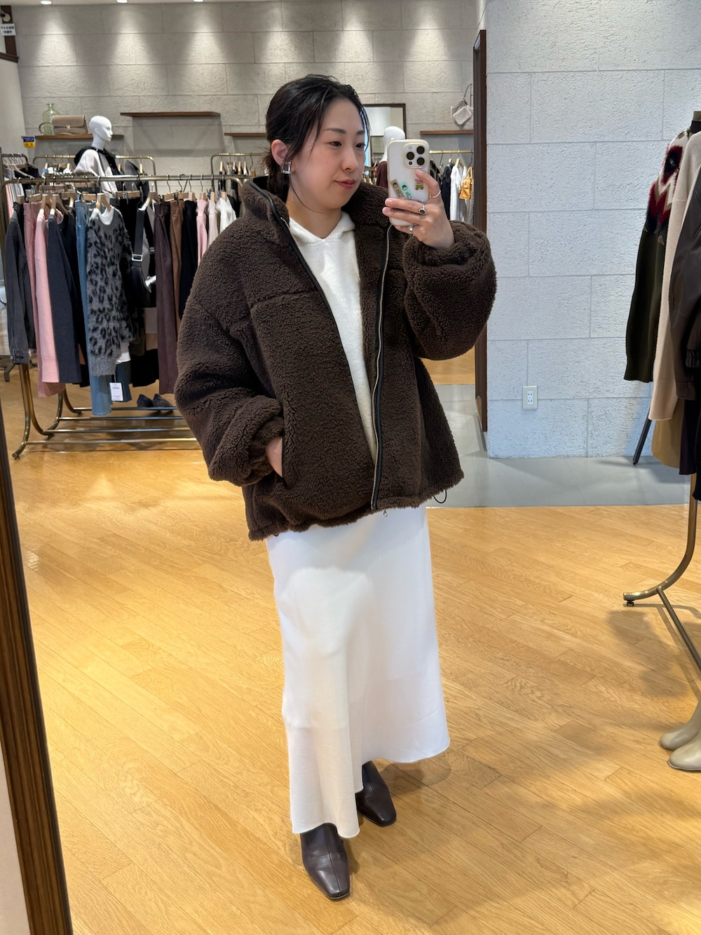 ブラウン系のその他アウター、ホワイト系のニット/セーター、ホワイト系のスカートを着用したレディースの秋コーディネートの1枚目の写真
