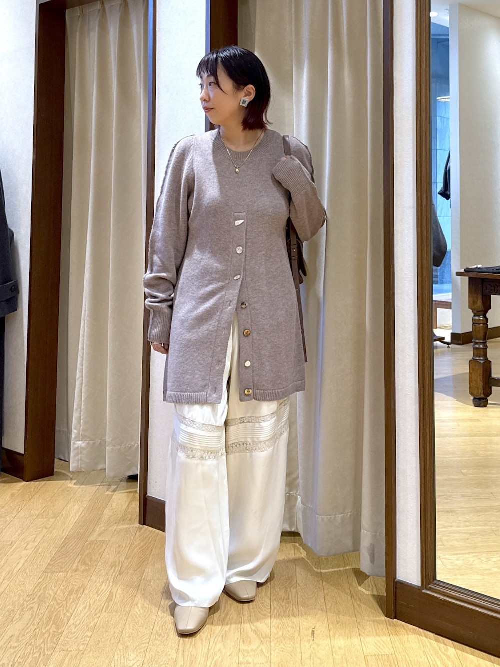 ベージュ系のニット/セーター、ブラウン系のショルダーバッグ、ホワイト系のその他パンツを着用したレディースの秋コーディネートの1枚目の写真