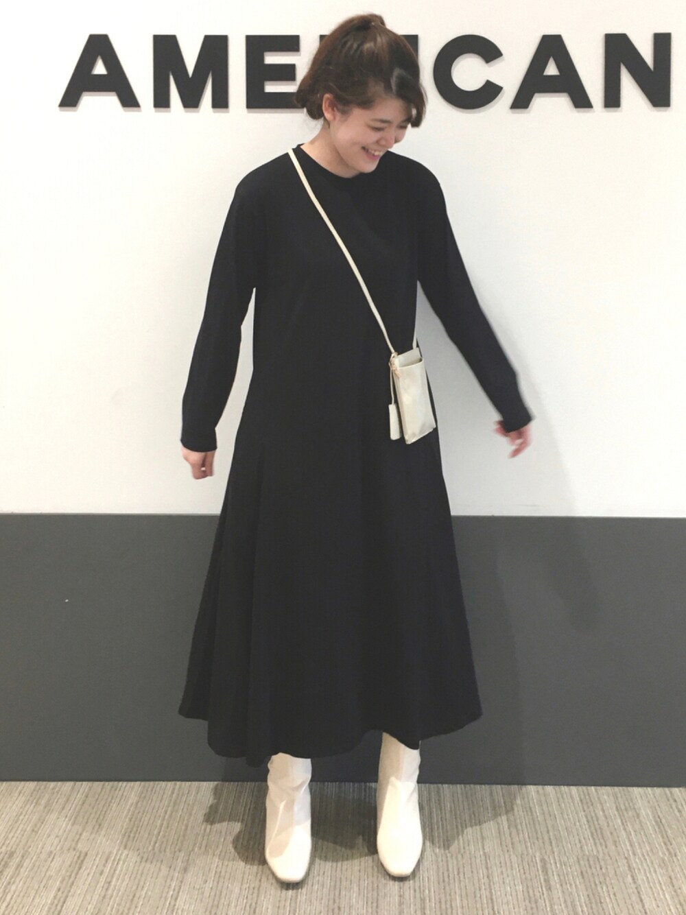 ブラック系のワンピース、ホワイト系のショルダーバッグ、ホワイト系のブーツを着用したレディースの秋コーディネートの1枚目の写真