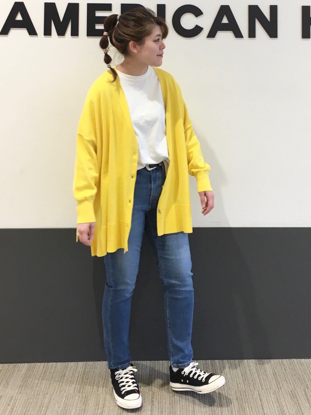 イエロー系のカーディガン/ボレロ、ブラック系のスニーカー、ホワイト系のTシャツ/カットソーを着用したレディースの春コーディネートの1枚目の写真