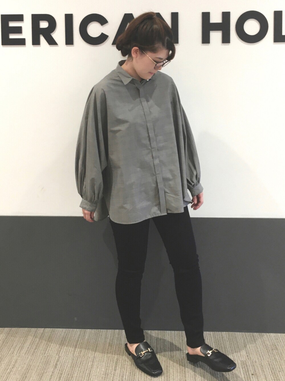 ブラック系のデニムパンツ、ブラック系のローファー、ホワイト系のトップスを着用したレディースの秋コーディネートの1枚目の写真