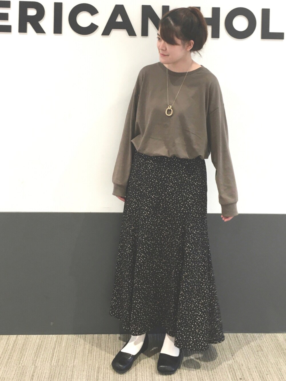 ブラウン系のTシャツ/カットソー、ブラック系のパンプス、その他のスカートを着用したレディースの秋コーディネートの1枚目の写真