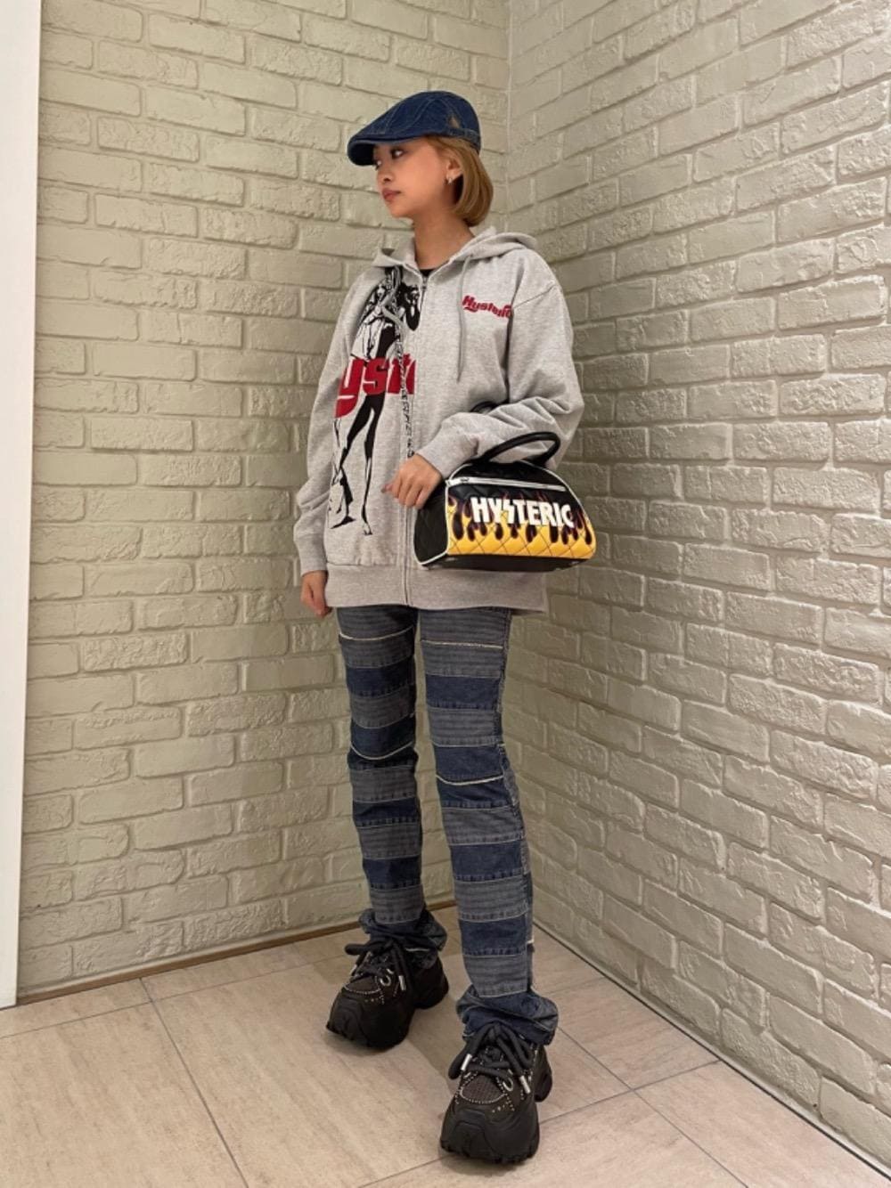 グレー系のパーカー、ブルー系のデニムパンツを着用したレディースの秋コーディネートの1枚目の写真