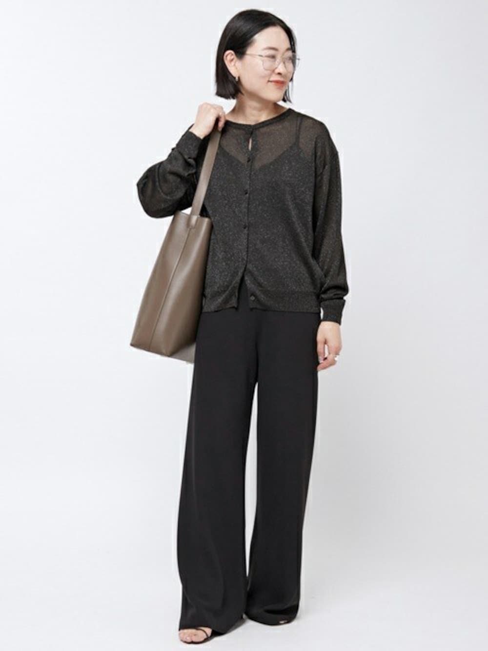 ブラック系のニット/セーター、ベージュ系のクラッチバッグ、シルバー系のリングを着用したレディースの夏コーディネートの1枚目の写真