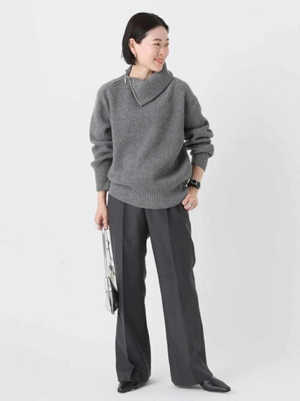 グレー系のニット/セーター、グレー系のスラックス、ブラック系のアナログ腕時計を着用したレディースの秋コーディネートの1枚目の写真