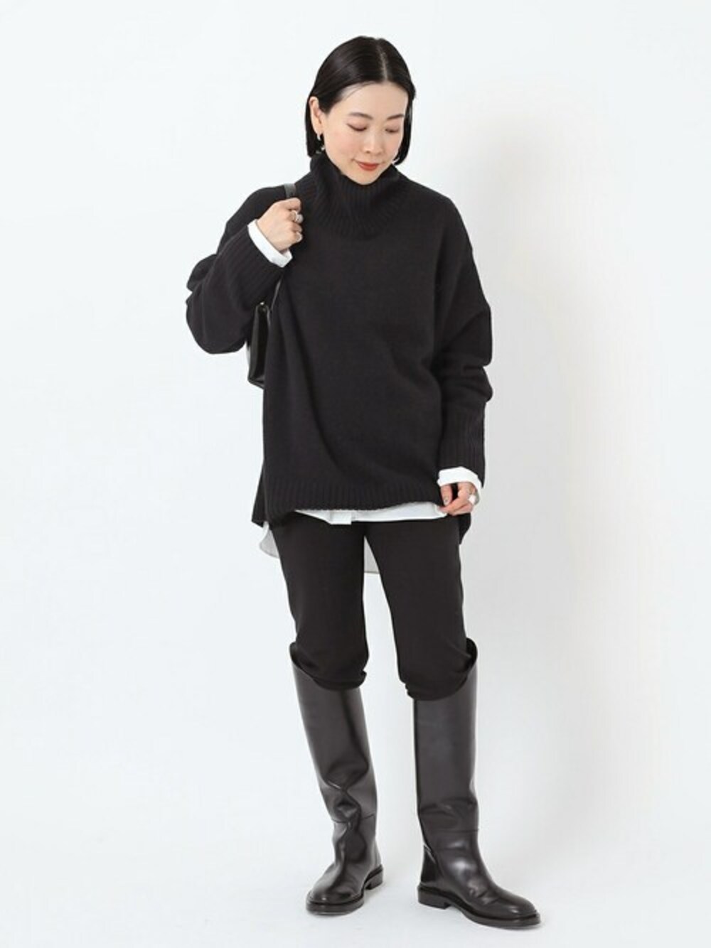 ブラック系のニット/セーター、ブラック系のその他パンツ、ホワイト系のシャツ/ブラウスを着用したレディースの秋コーディネートの1枚目の写真