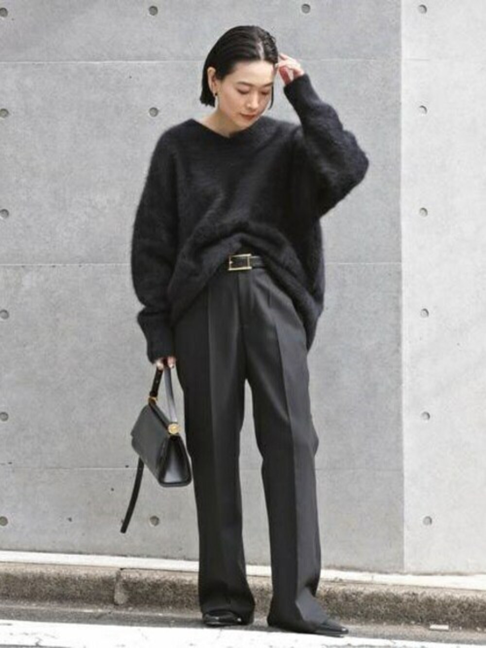 ブラック系のスラックス、ブラック系のニット/セーターを着用したレディースの冬コーディネートの1枚目の写真