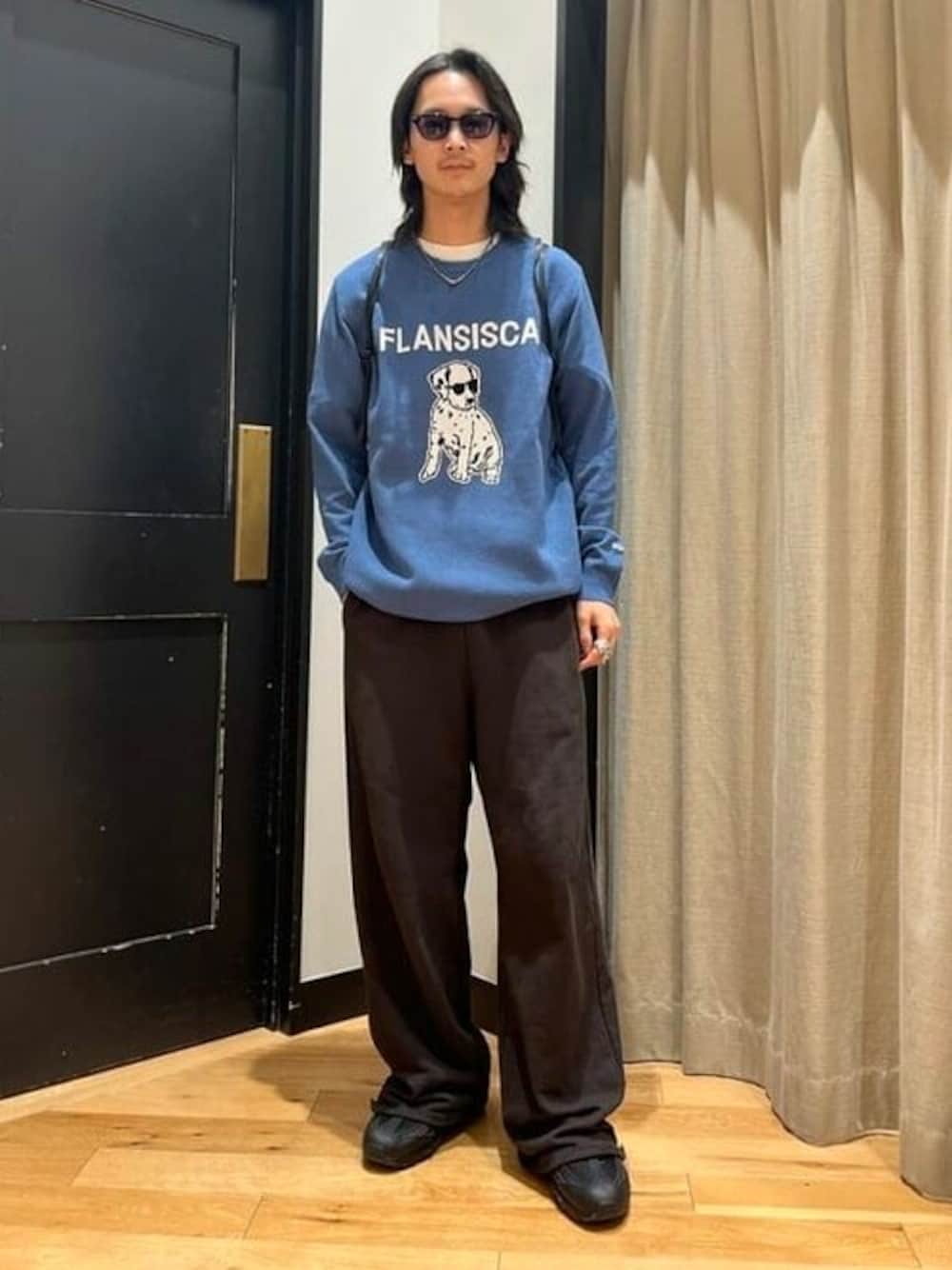 ブルー系のニット/セーター、ブラック系のサングラスを着用したメンズの冬コーディネートの1枚目の写真