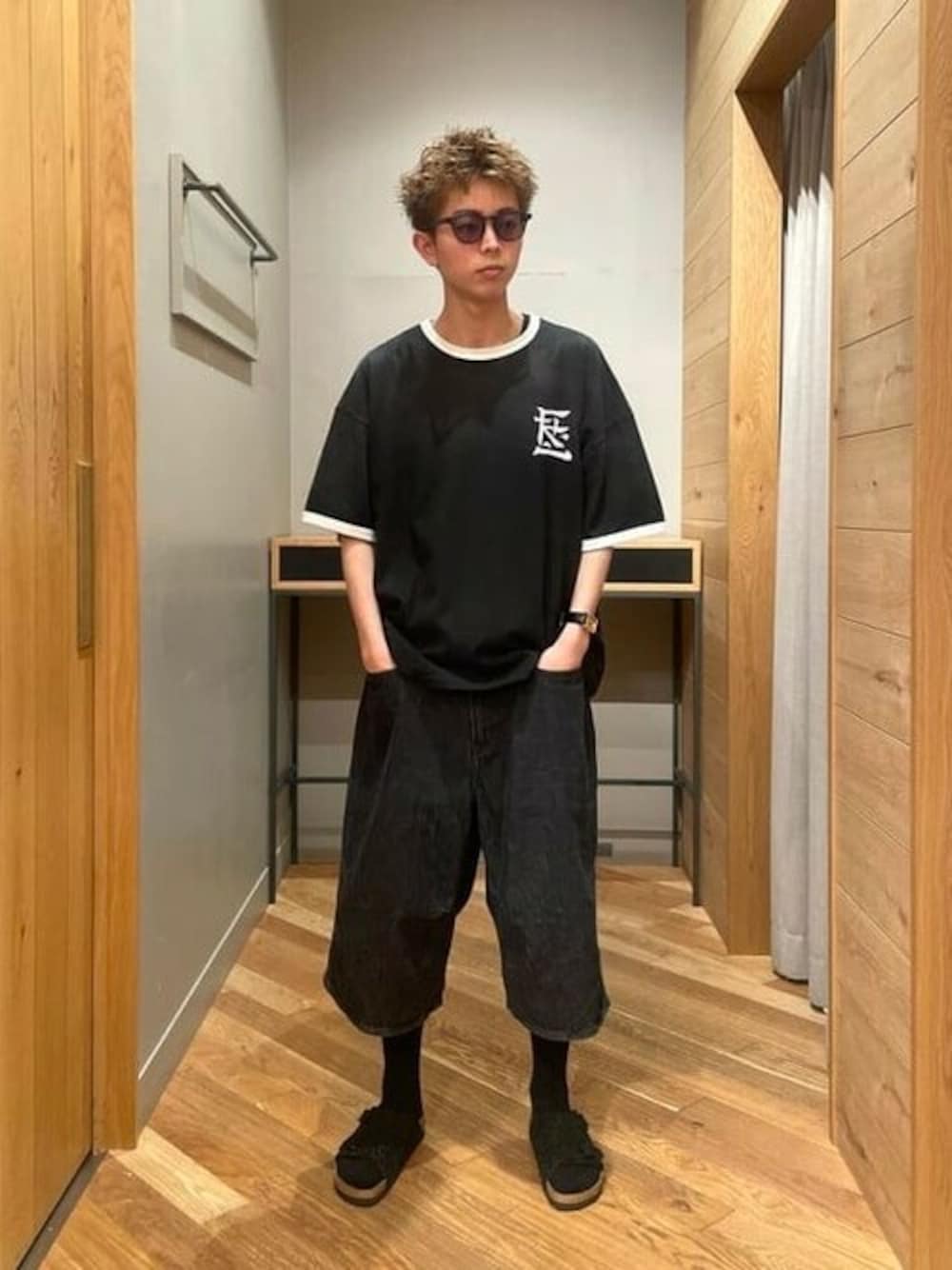 ブラック系のTシャツ/カットソー、ブラック系のデニムパンツ、ブラック系のサンダルを着用したメンズの夏コーディネートの1枚目の写真