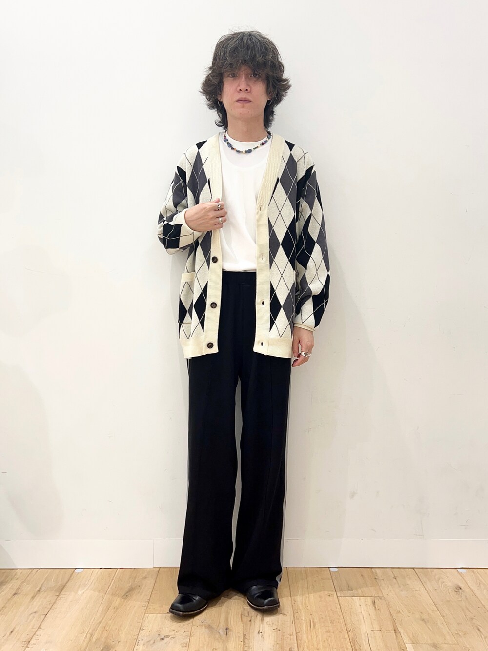 ベージュ系のTシャツ/カットソー、ブラック系のカーディガン/ボレロ、ブラック系のブーツを着用したメンズの秋コーディネートの1枚目の写真