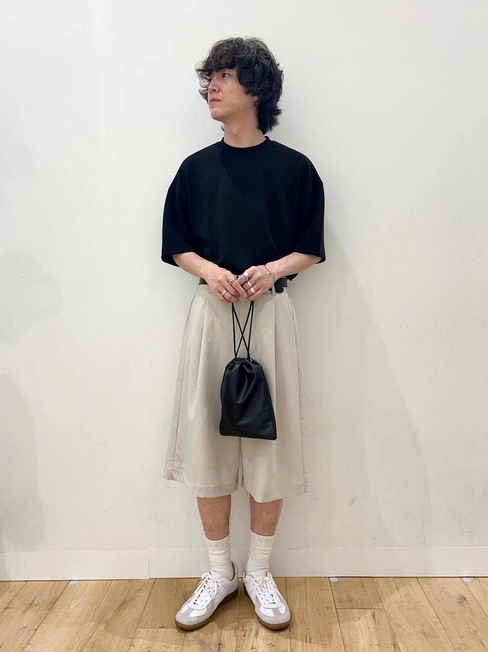 ブラック系のTシャツ/カットソー、ブラック系のショルダーバッグ、ホワイト系のスニーカーを着用したメンズの夏コーディネートの1枚目の写真